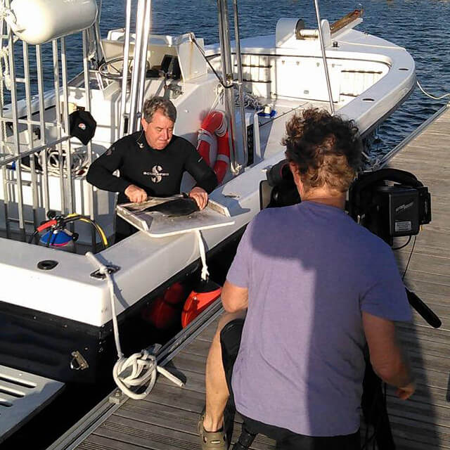 An image of a professional film crew on board a keys shark diving trip in the Florida Keys.